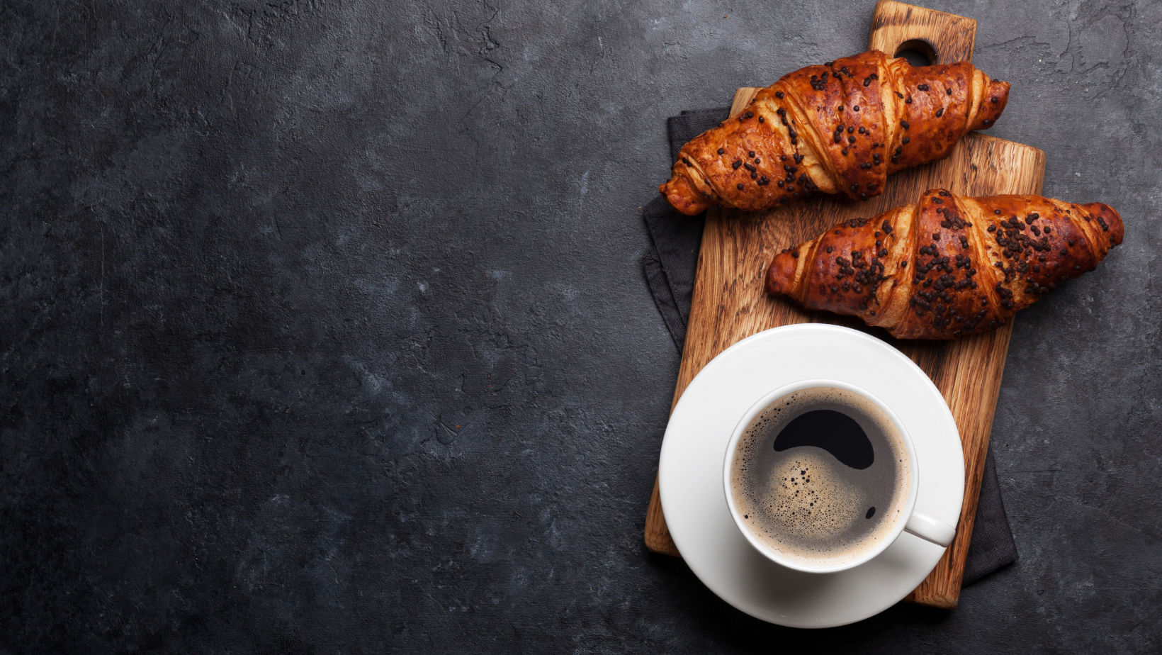 Coffee cup with homemade croissants on cutting board